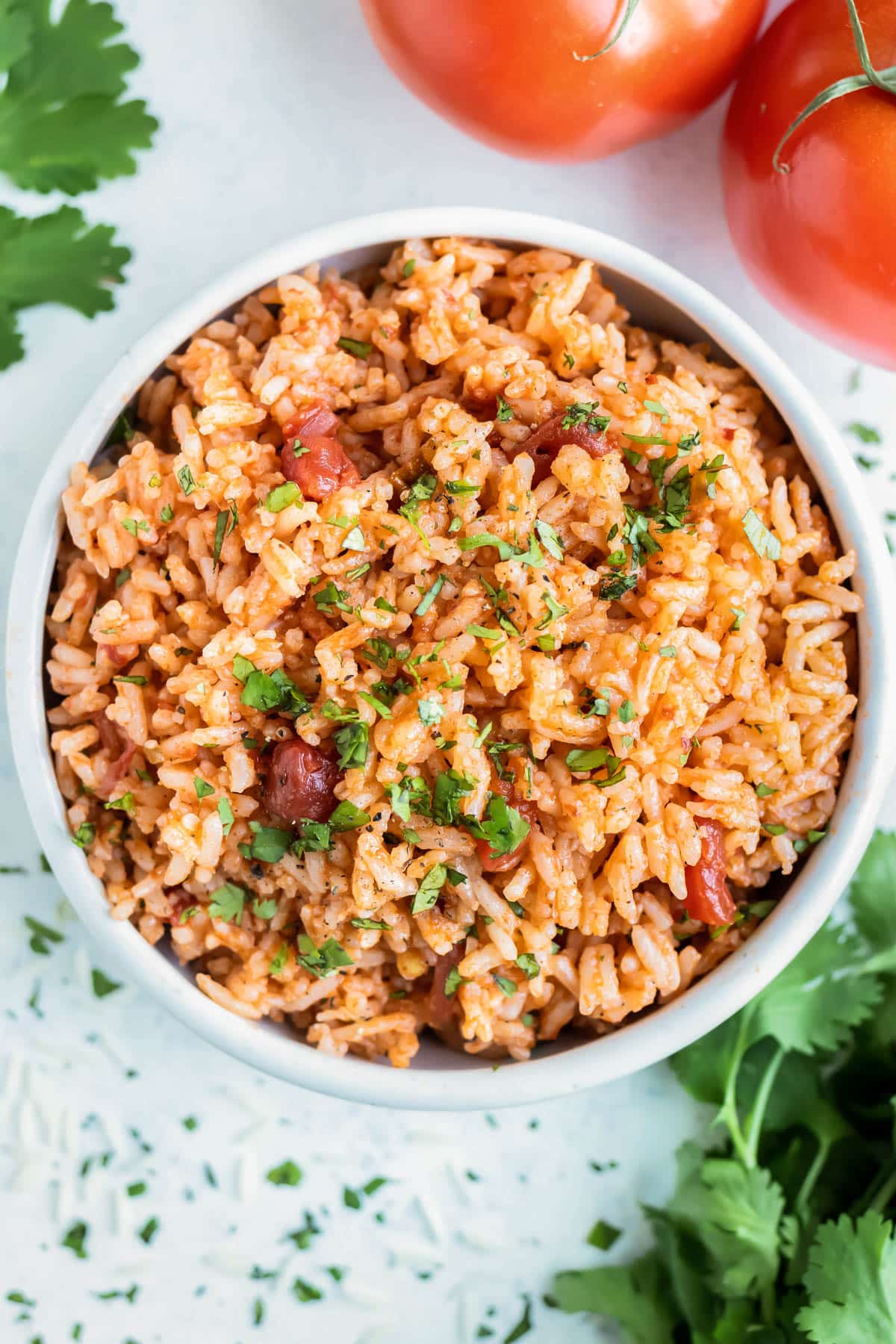 A white bowl is full of Instant Pot Mexican Rice made with salsa, white rice, and cilantro.