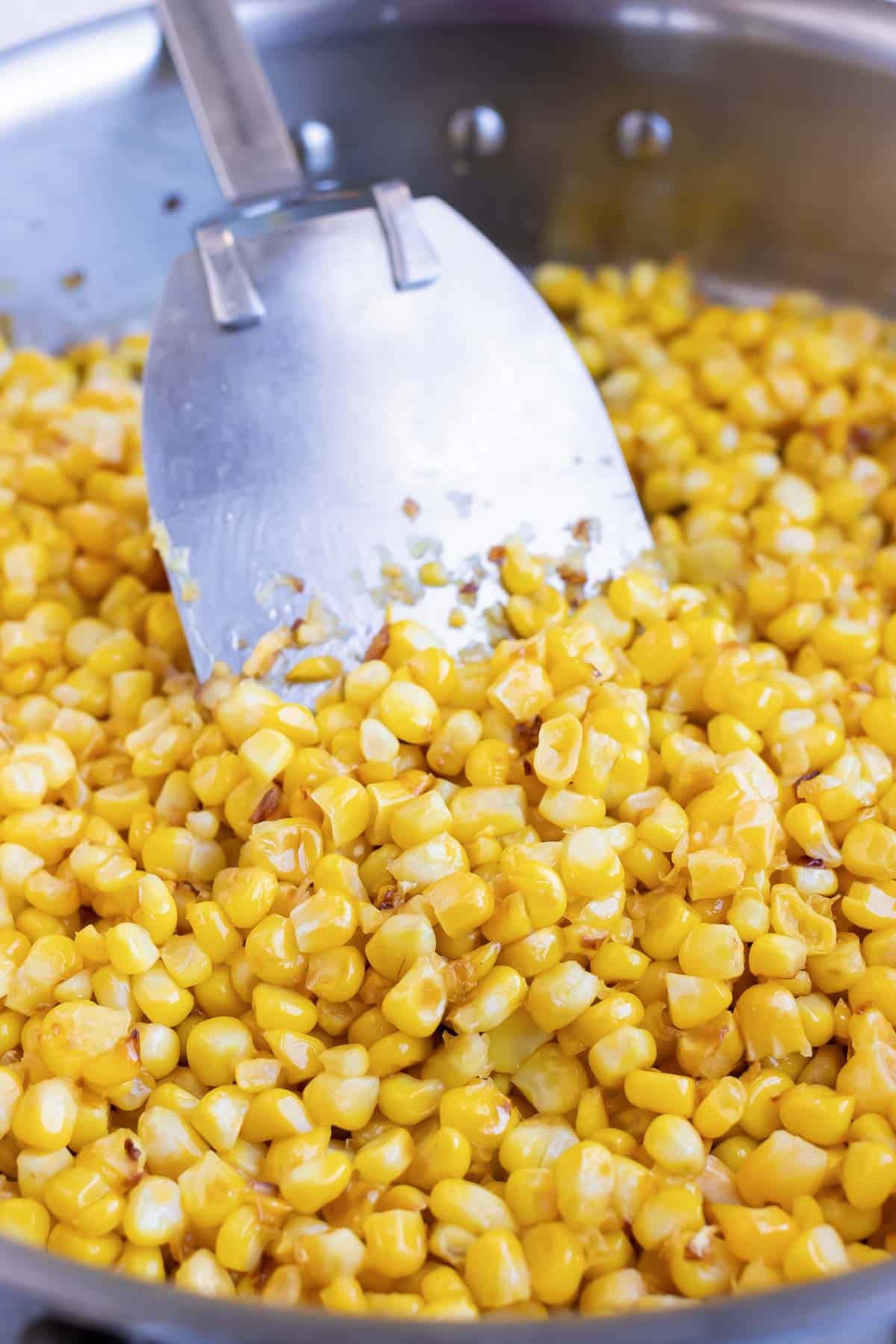 Corn is cooked in a skillet.
