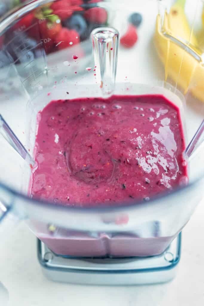 Thick and creamy smoothie is made in a blender.