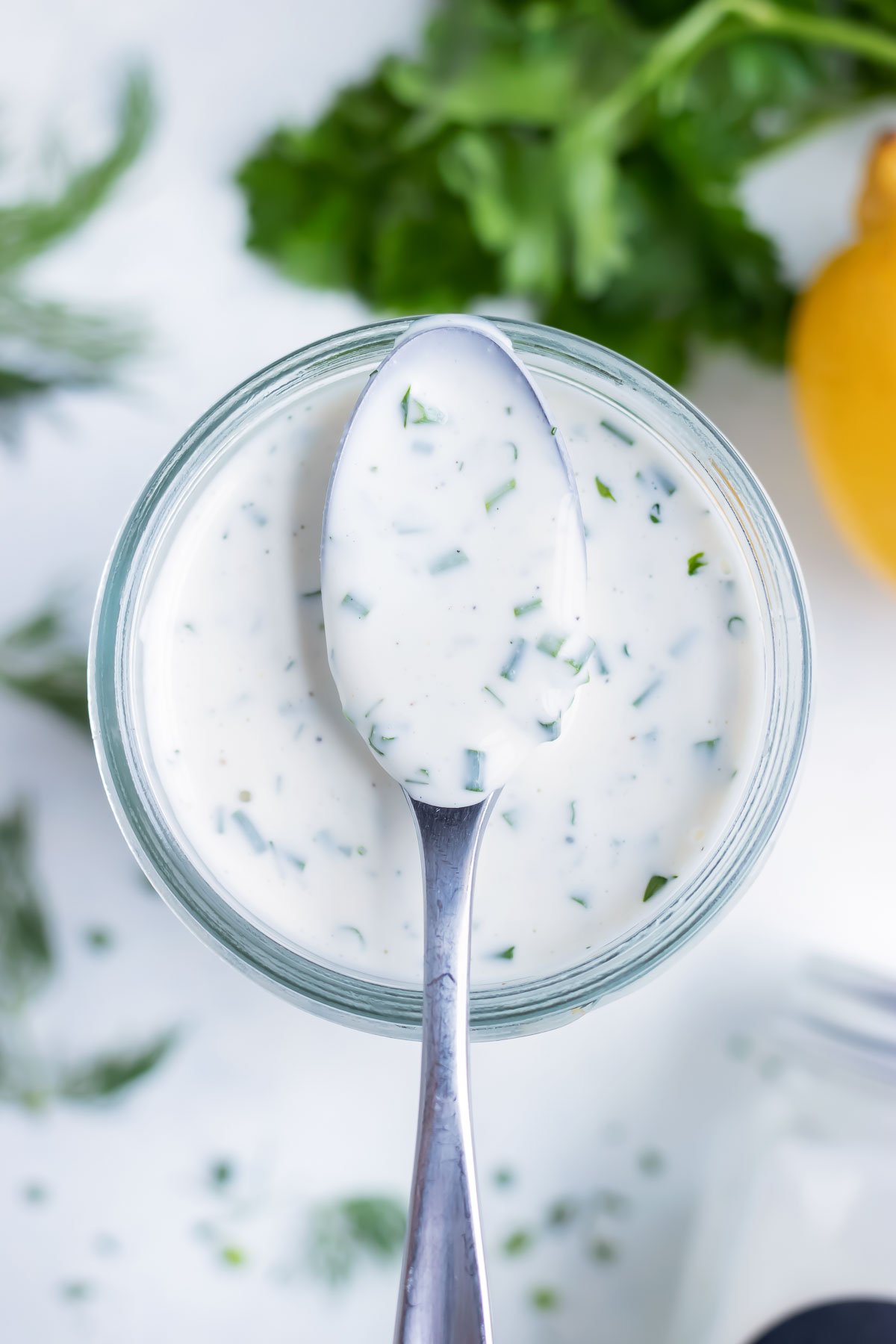 A metal spoon is set on top of the jar of homemade dressing.