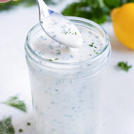 Homemade ranch dip is served from a jar with a spoon.