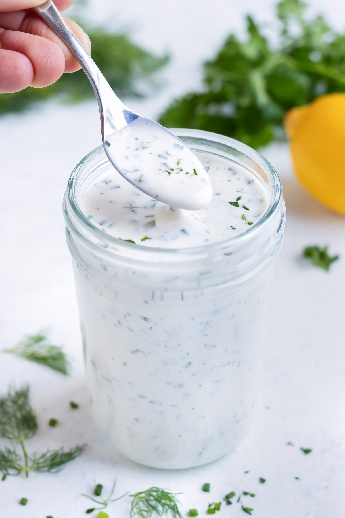 Homemade ranch dip is served from a jar with a spoon.