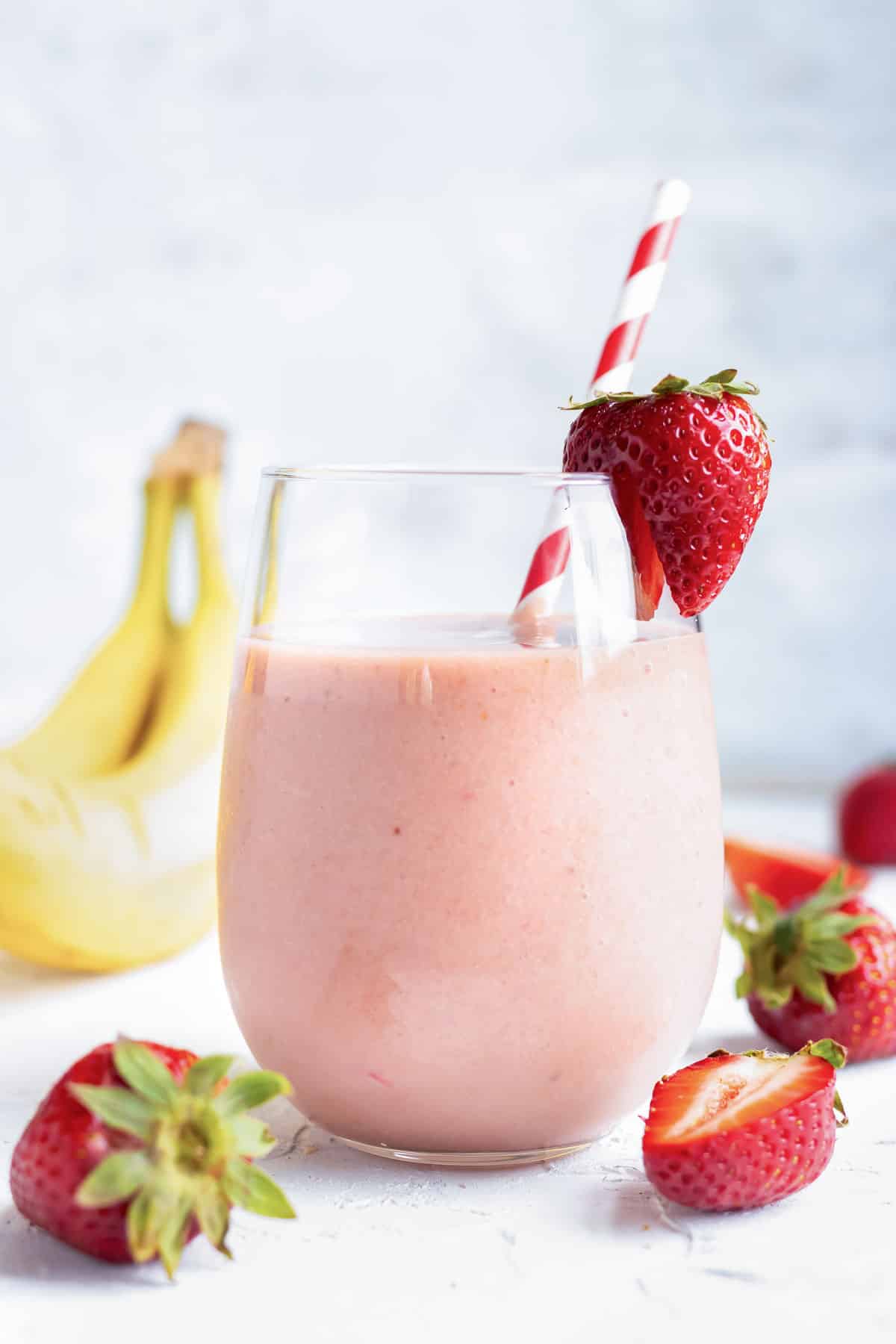 A serving of an easy and healthy smoothie in a glass with a straw.