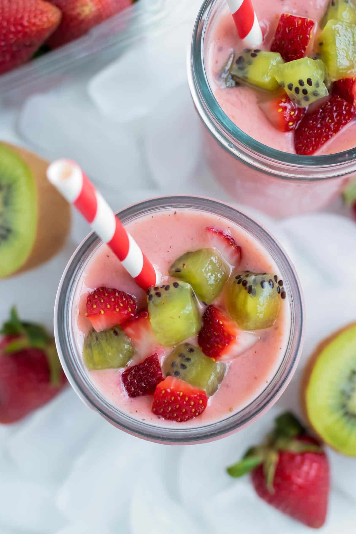 A strawberry kiwi smoothie is served on the counter.