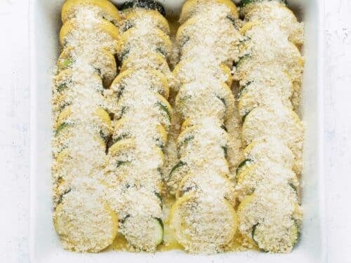 Seasonings and cheese are sprinkled on top of the sliced squash.