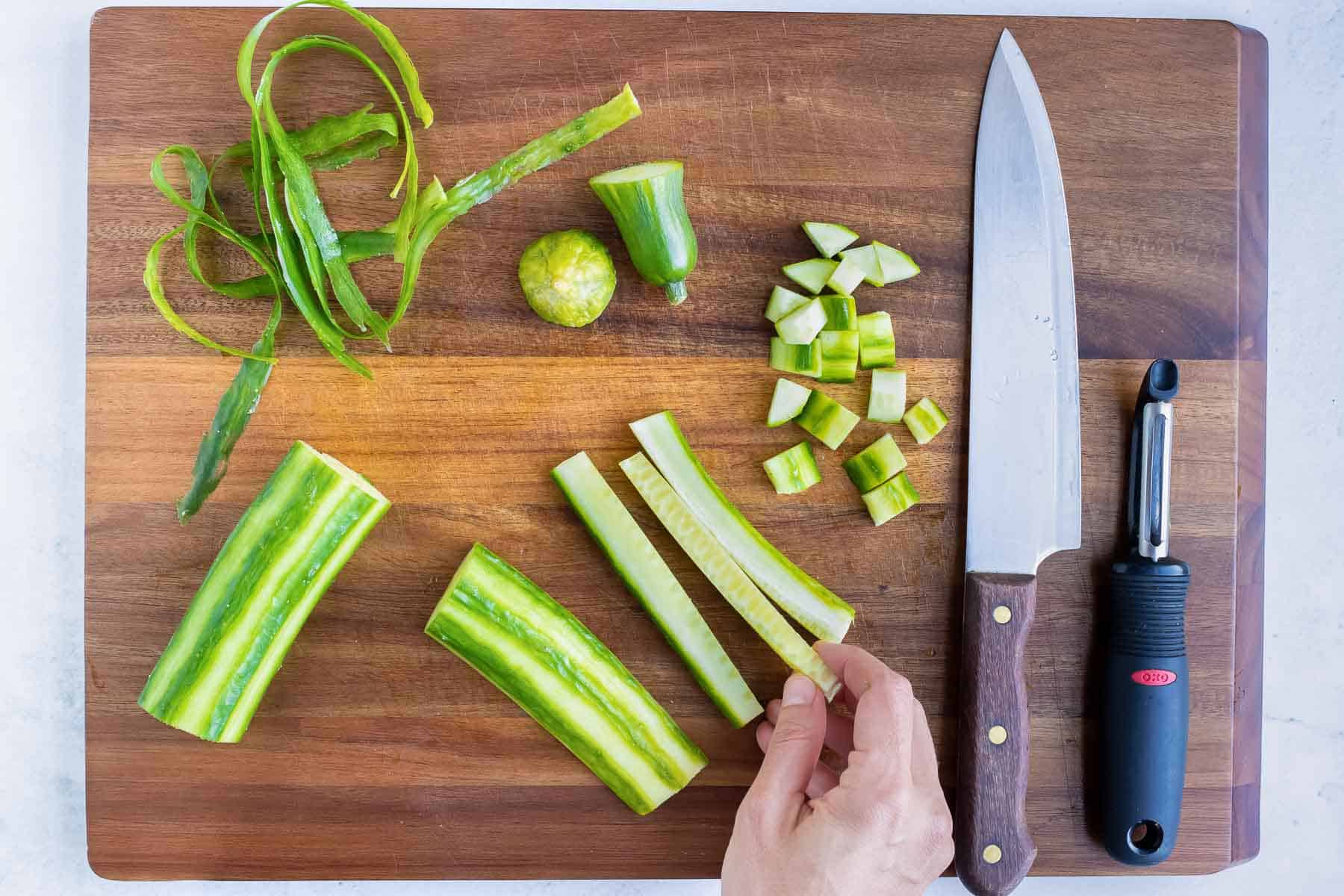 A cucumber is cut into strips and then diced.