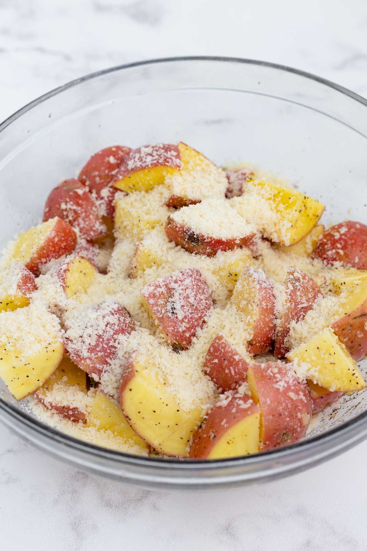 Parmesan cheese is sprinkled over the seasoned potatoes.