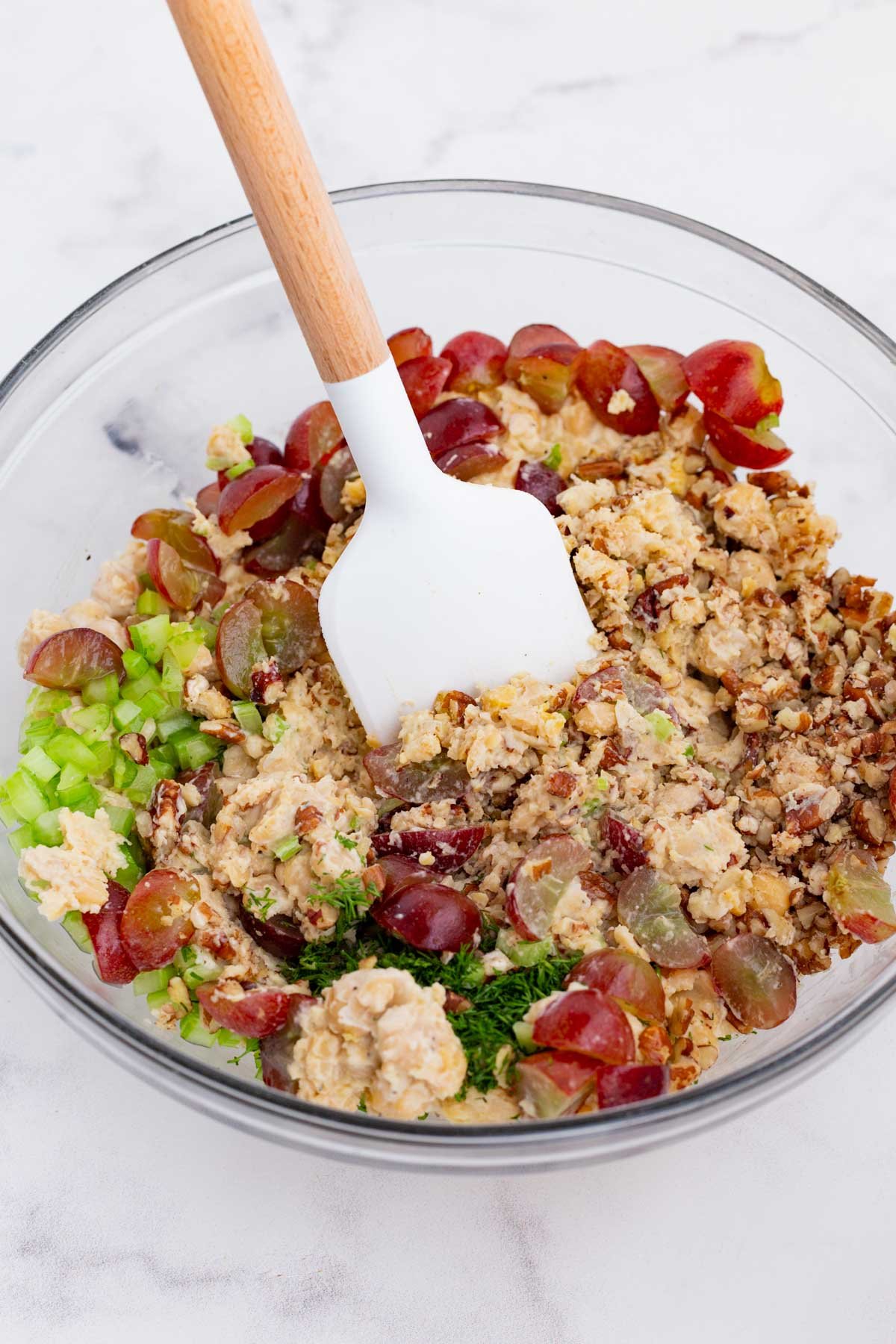 A spatula stirs the chickpea salad.