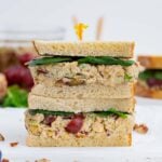 Two halves of a chickpea salad sandwich are stacked on top of each other.