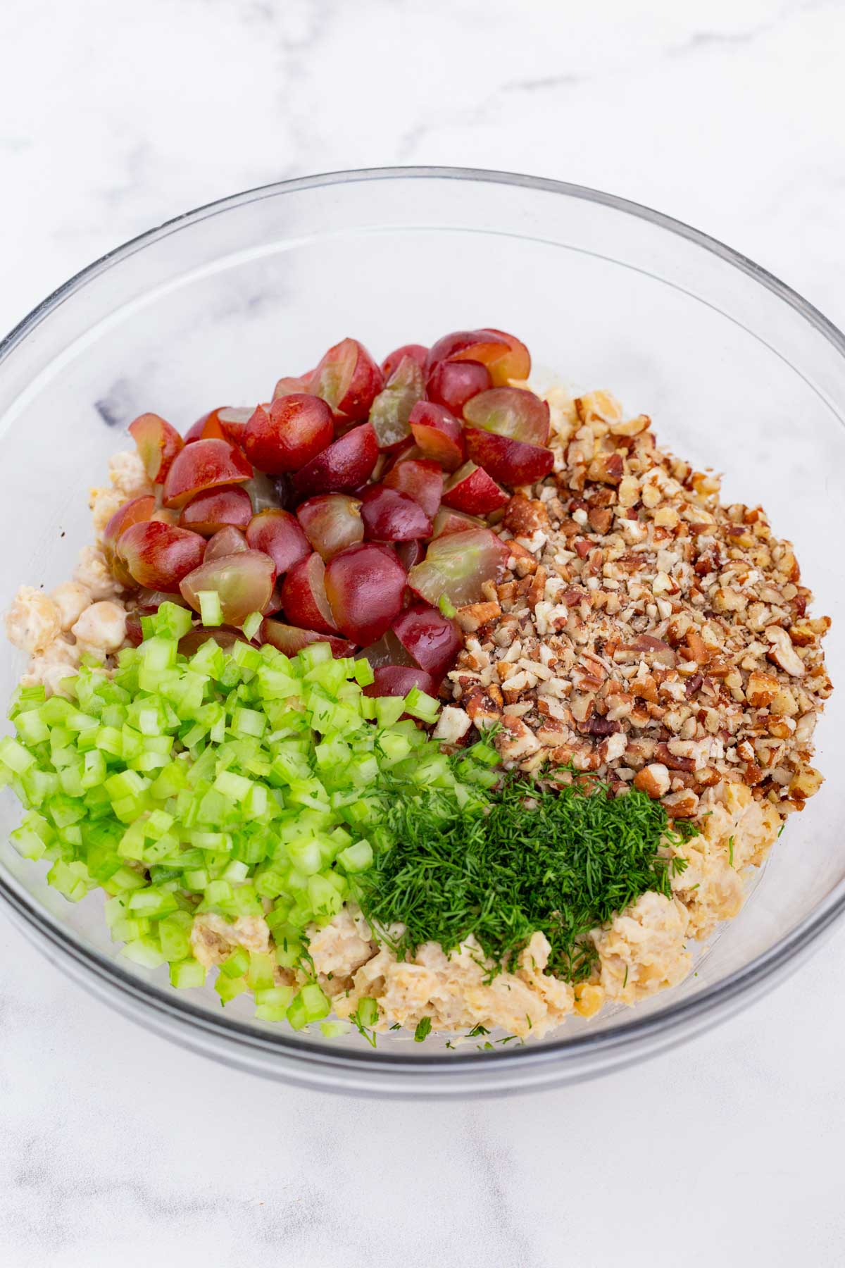 Pecans, grapes, celery, and dill is added to the chickpea salad.