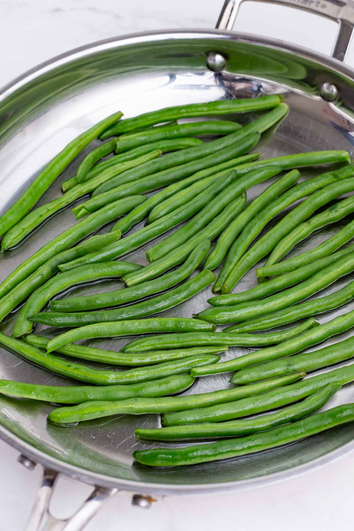 Green beans are cooked in a skillet.