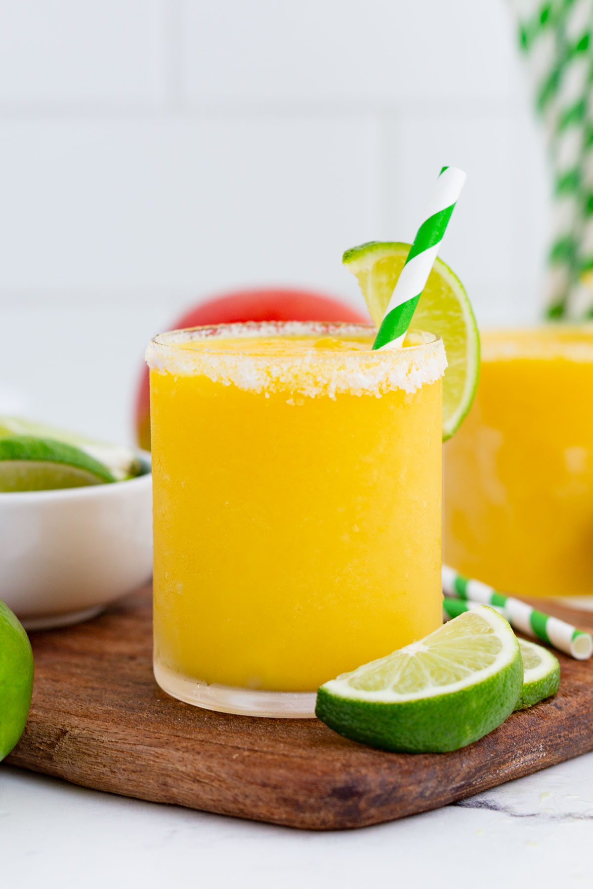 Two glasses of mango margarita are ready to drink.
