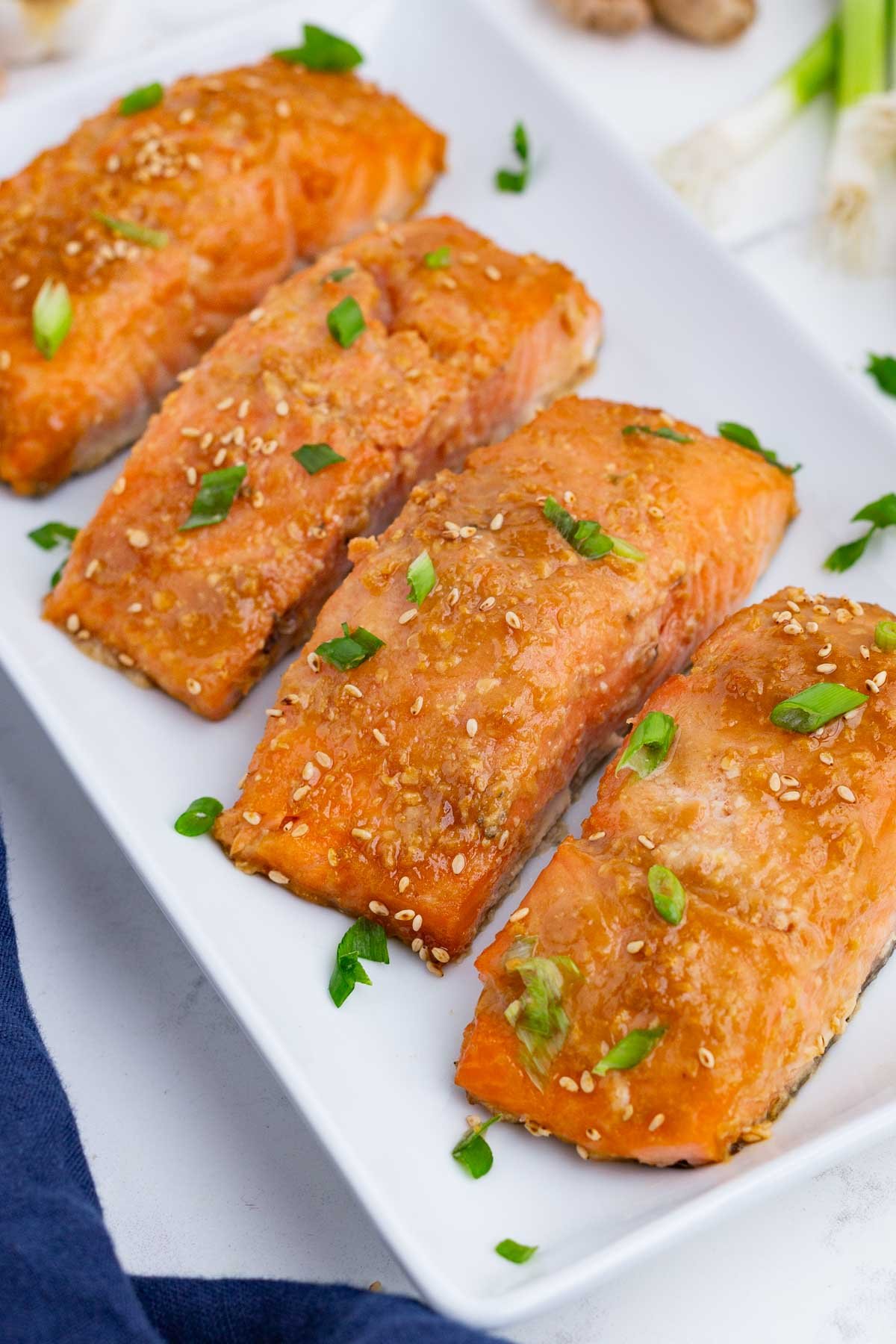 Four salmon filets are served on a white dish.