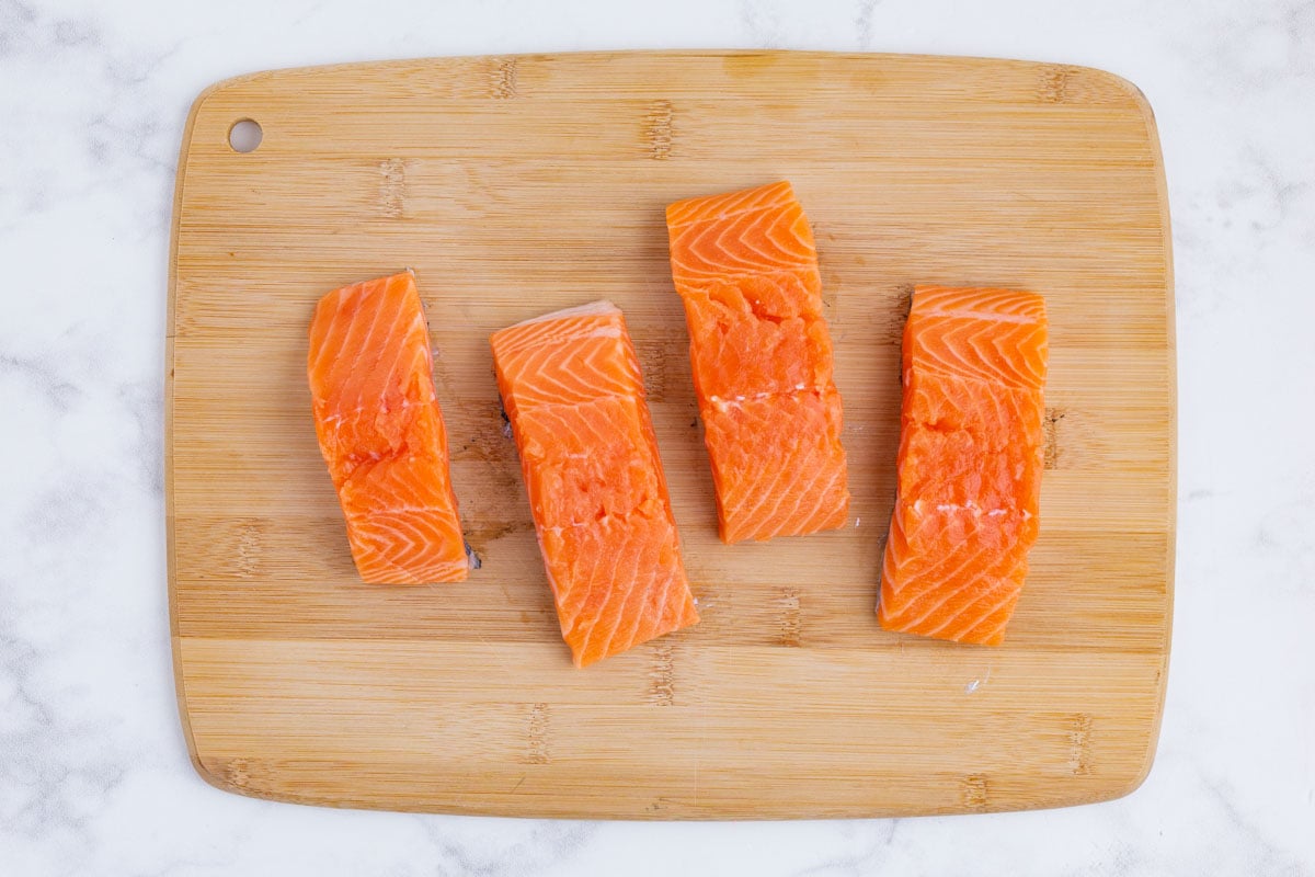 A salmon filet is cut into smaller pieces.