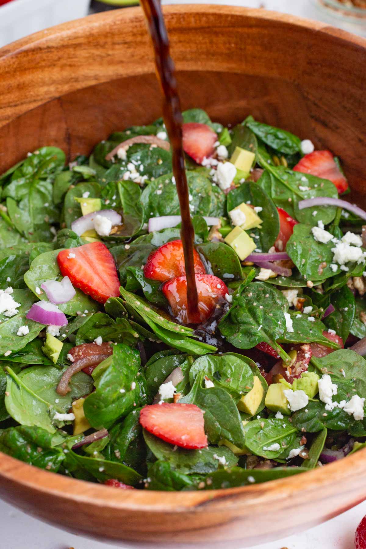 Dressing is drizzled over the top of this easy spinach salad.
