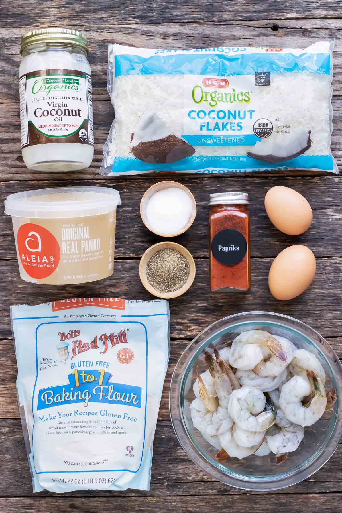 Unsweetened shredded coconut, coconut oil, Panko bread crumbs, egg, flour, and shrimp as ingredients for a coconut shrimp recipe.