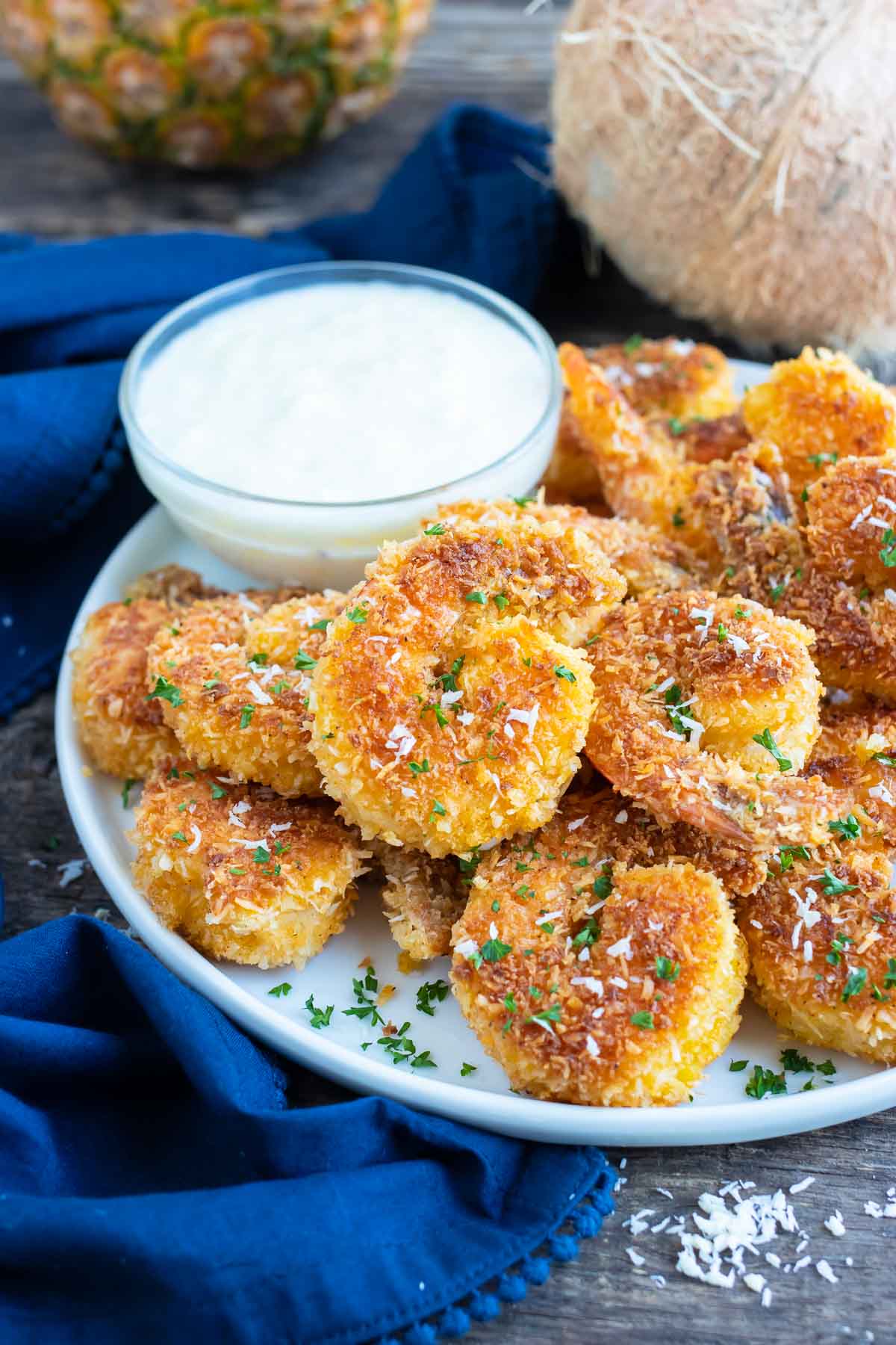 Golden shrimp that are covered in a shredded coconut and bread crumb coating.