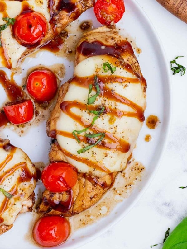 Caprese chicken is made with mozzarella cheese, tomatoes, and basil, then topped with a drizzle of balsamic.