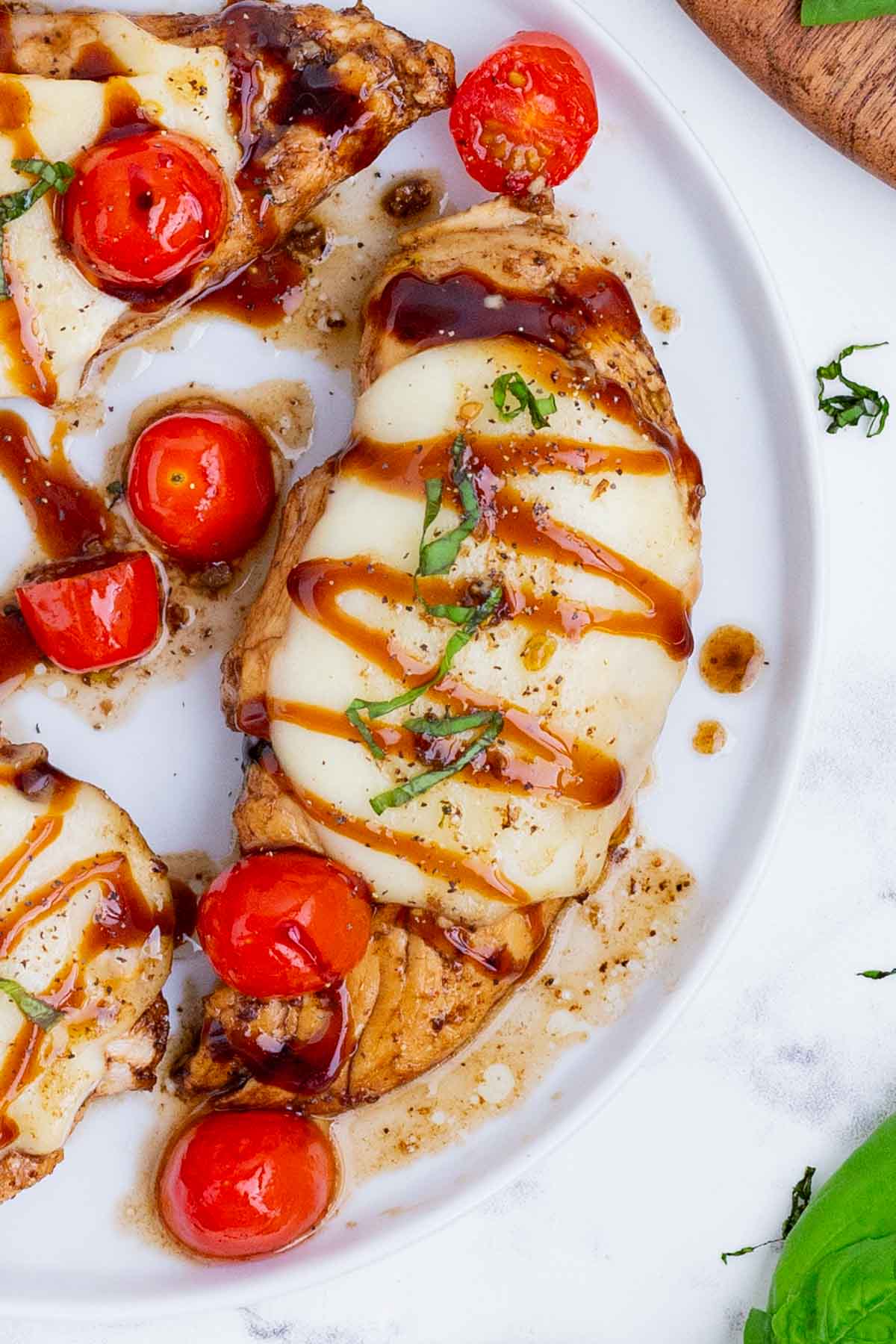 Caprese chicken is made with mozzarella cheese, tomatoes, and basil, then topped with a drizzle of balsamic.