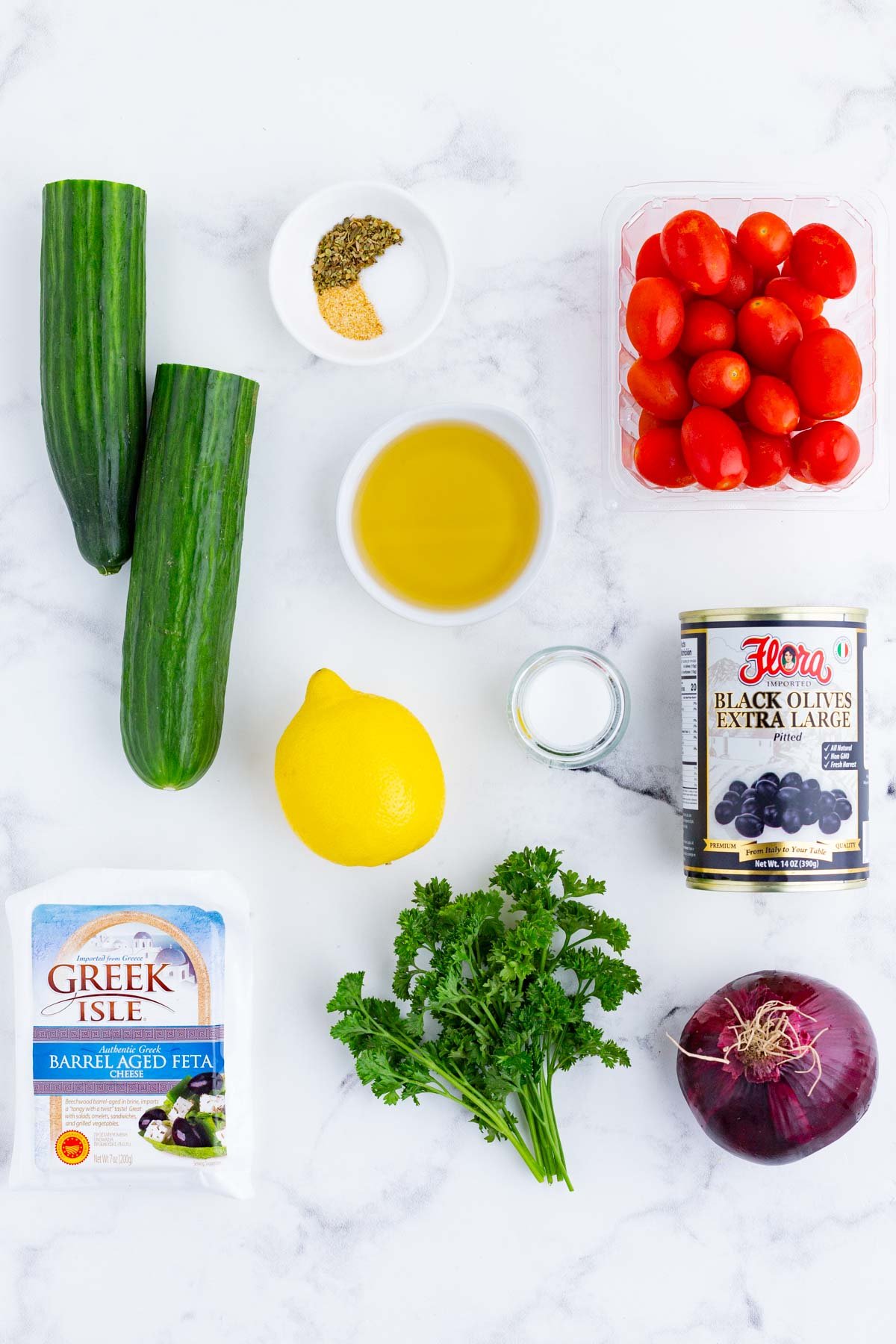 Cucumber, tomatoes, onion, olive, feta, lemon, and oil are the ingredients for this dish.