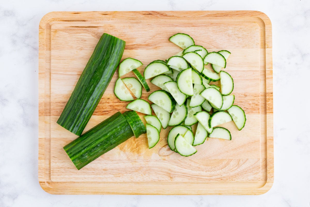Cucumber is sliced on a cutting board.
