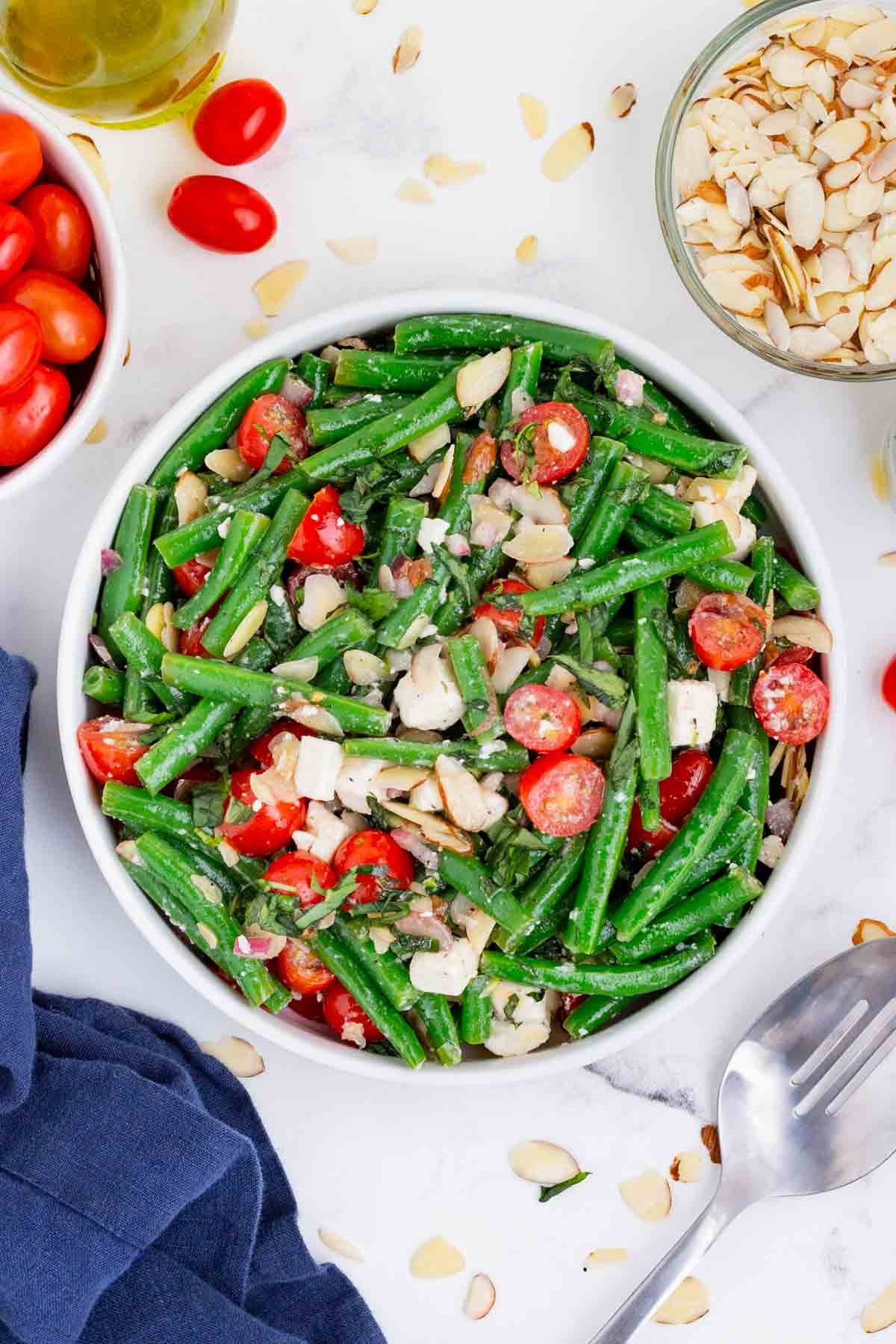 An overhead view of green bean salad in a white bowl.