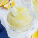 A spoon scoops out a bite of lemon sorbet.