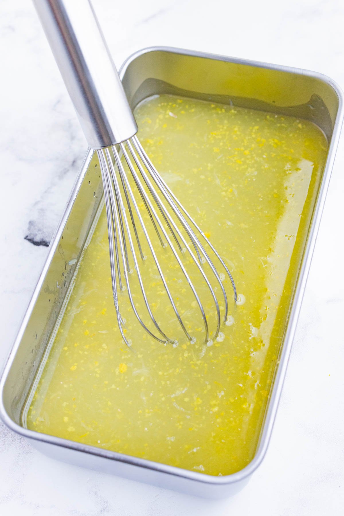 A whisk stirs the lemon sorbet ingredients.