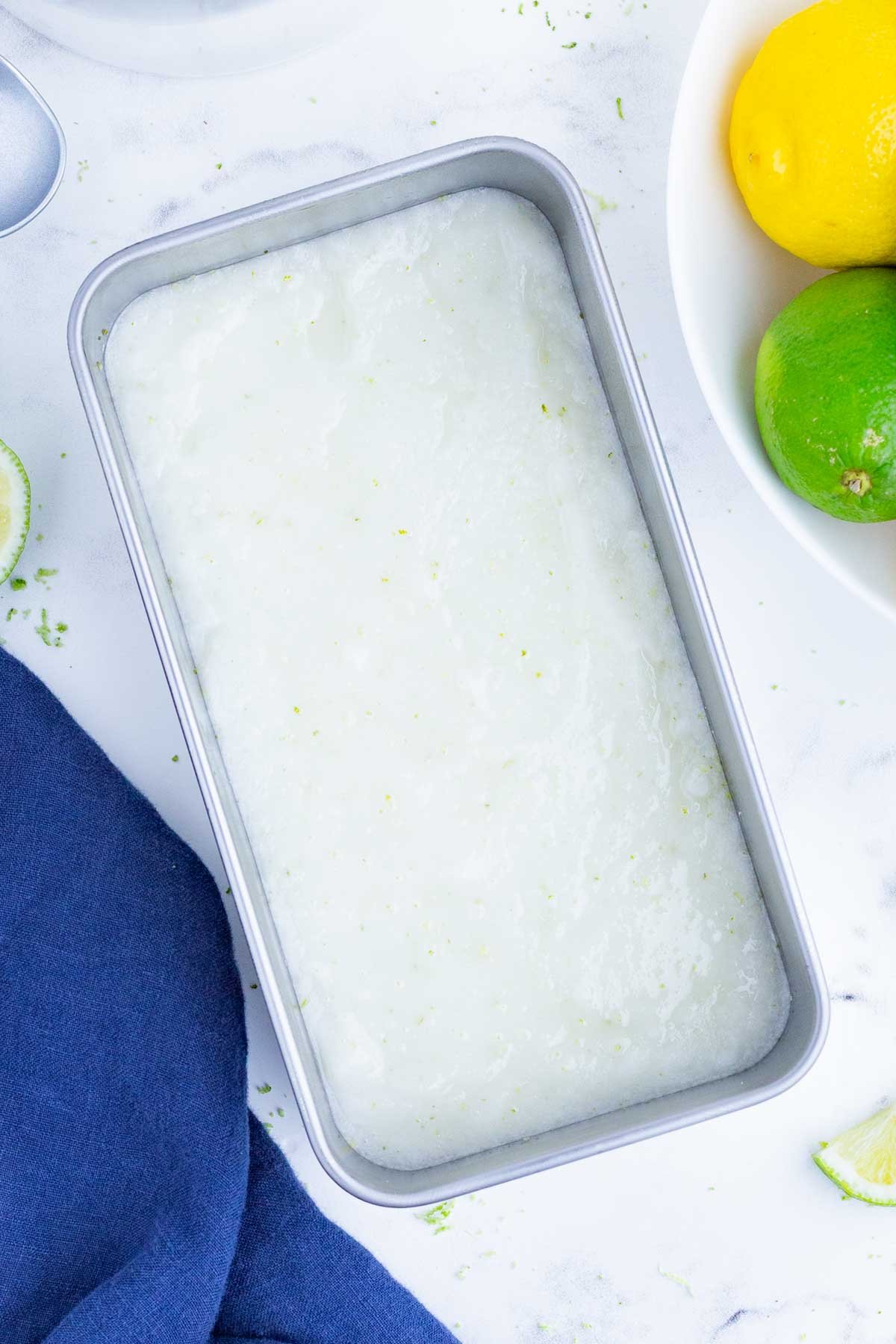 Blended lime sorbet is added to a loaf pan.