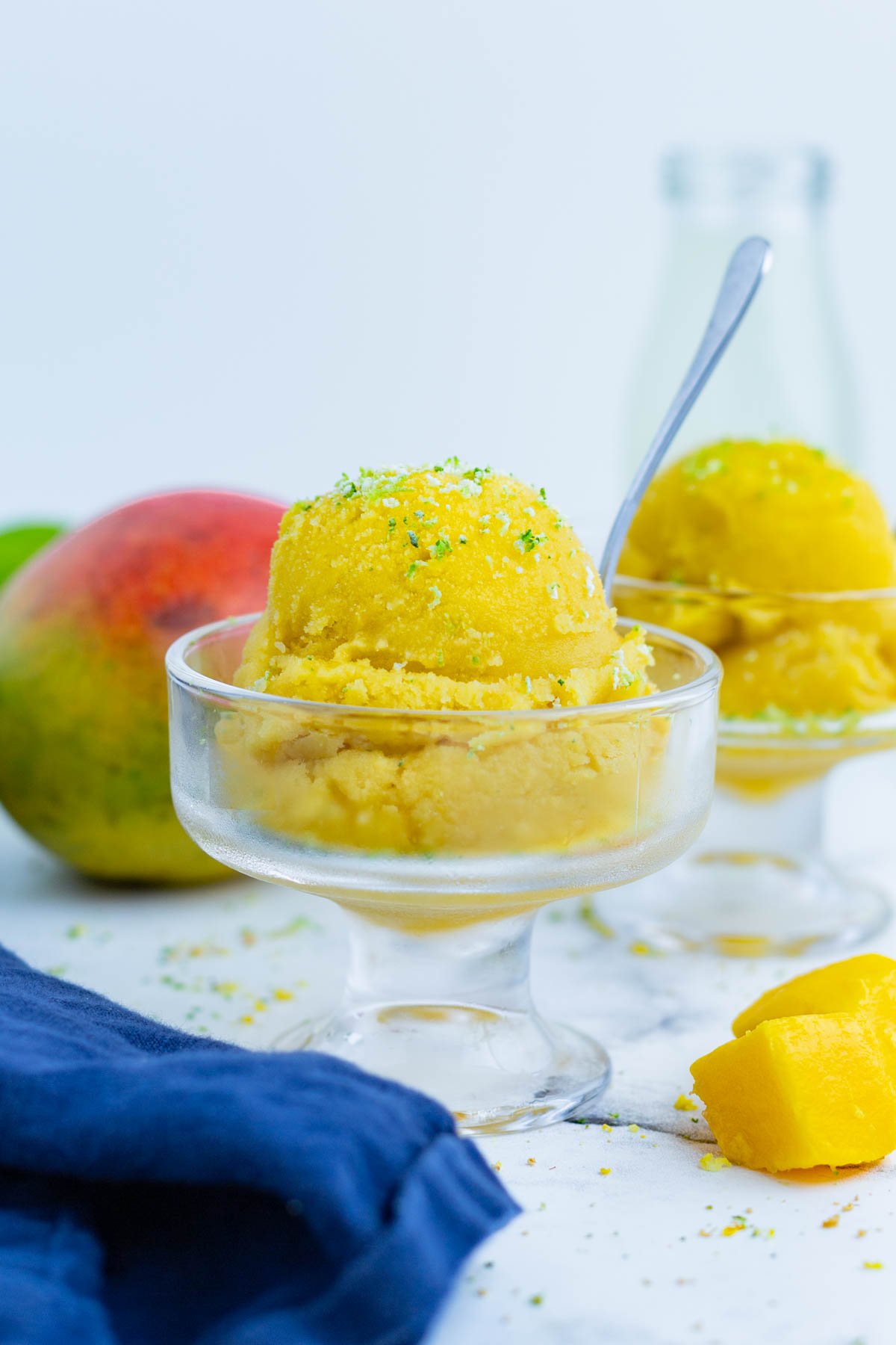 Two bowls full of mango sorbet are served up.