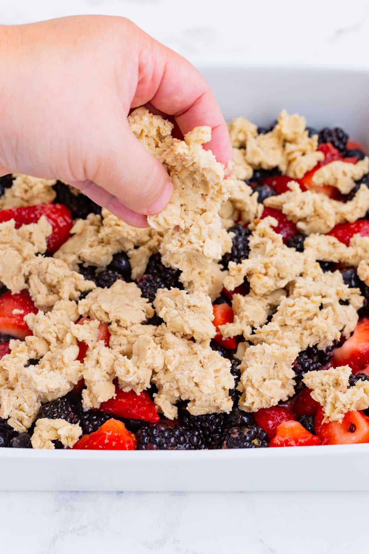 The remaining crumble mixture is spread over the berries.
