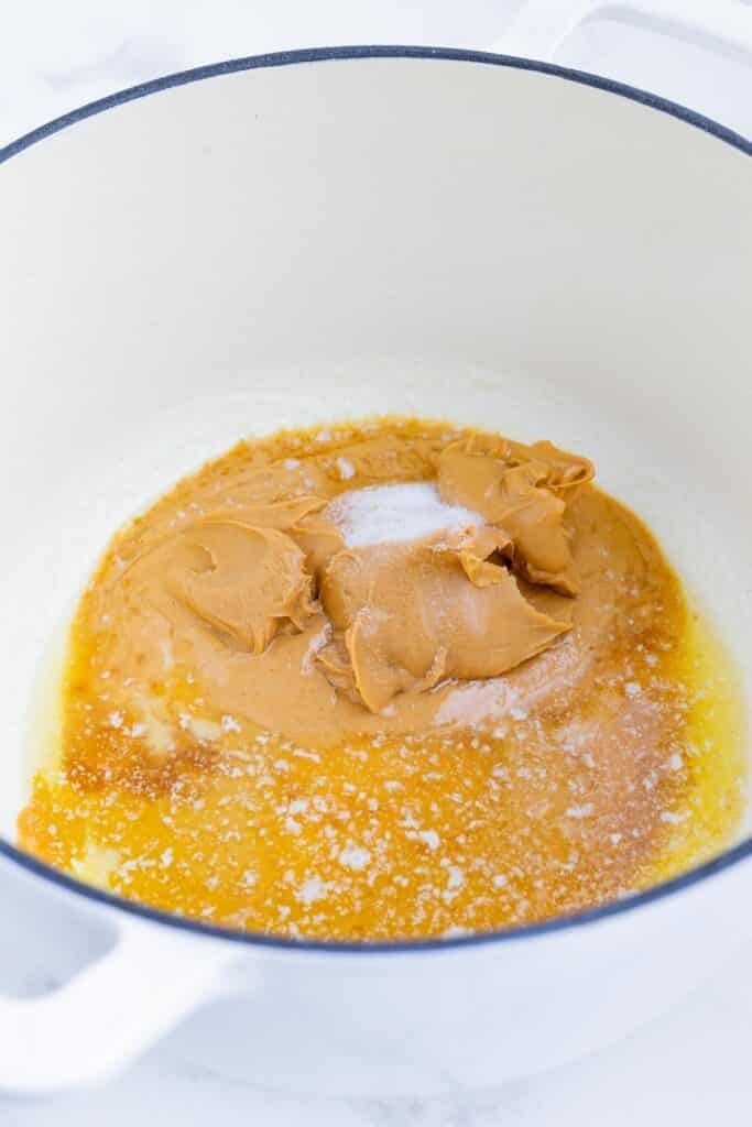 Melted butter and peanut butter are stirred together.