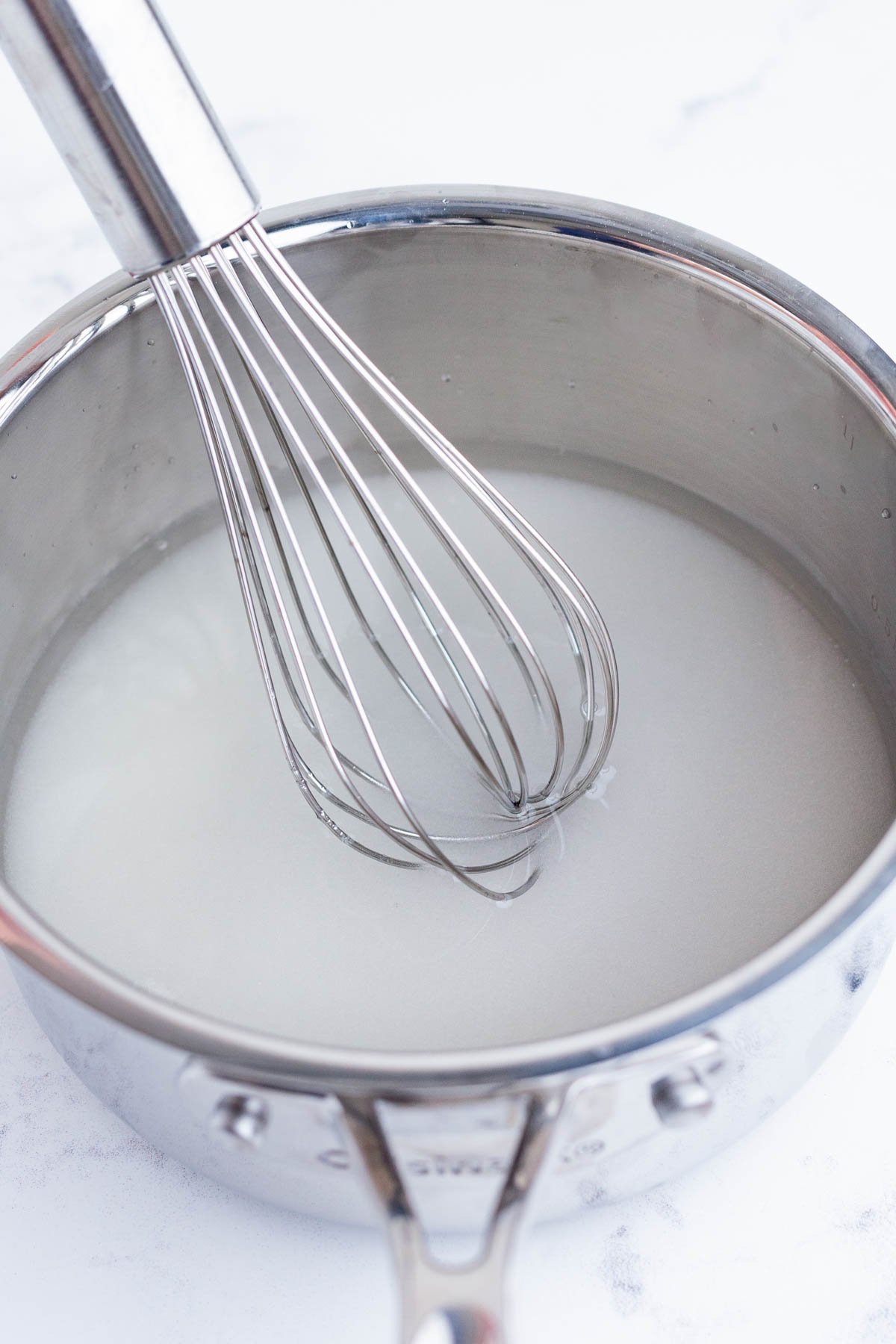 Sugar and water are added to a saucepan.