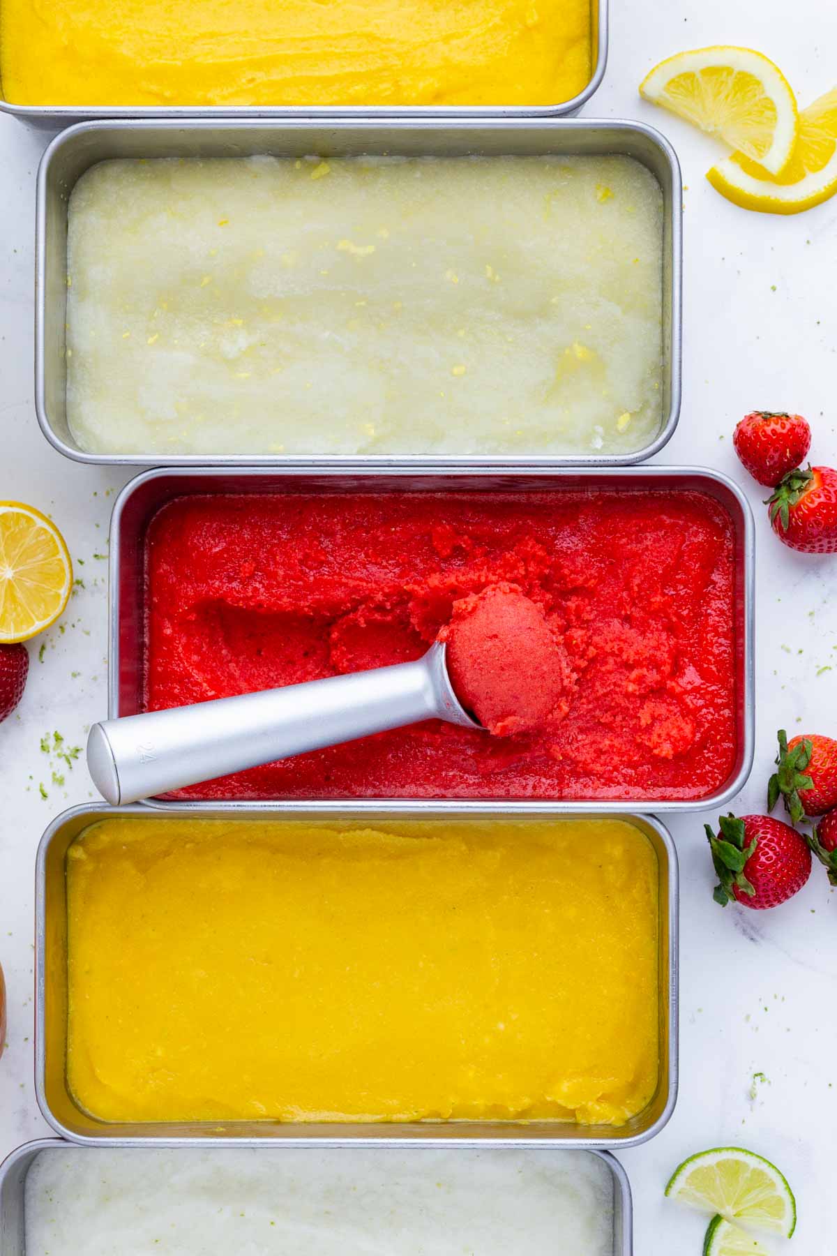 Five pans of homemade sorbet sit on the counter before serving.