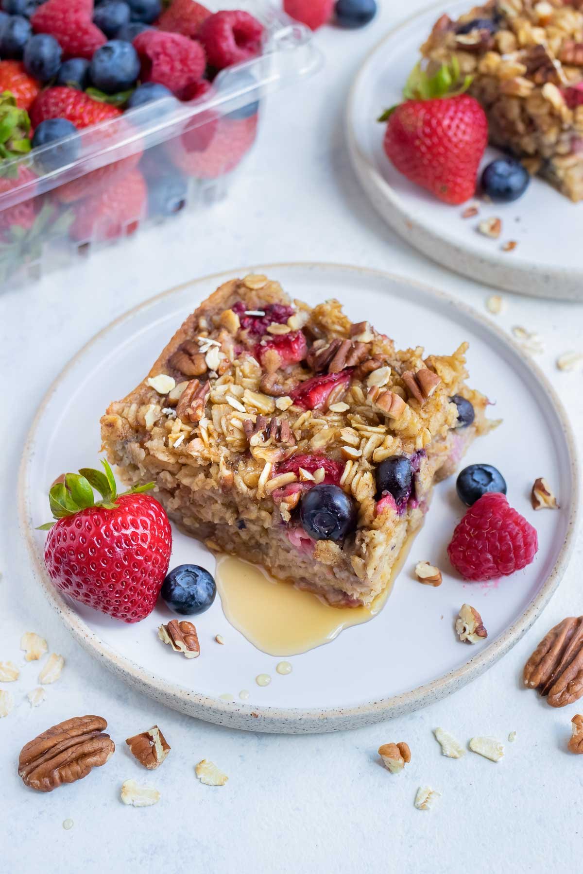 Baked oatmeal with berries is drizzled with syrup.