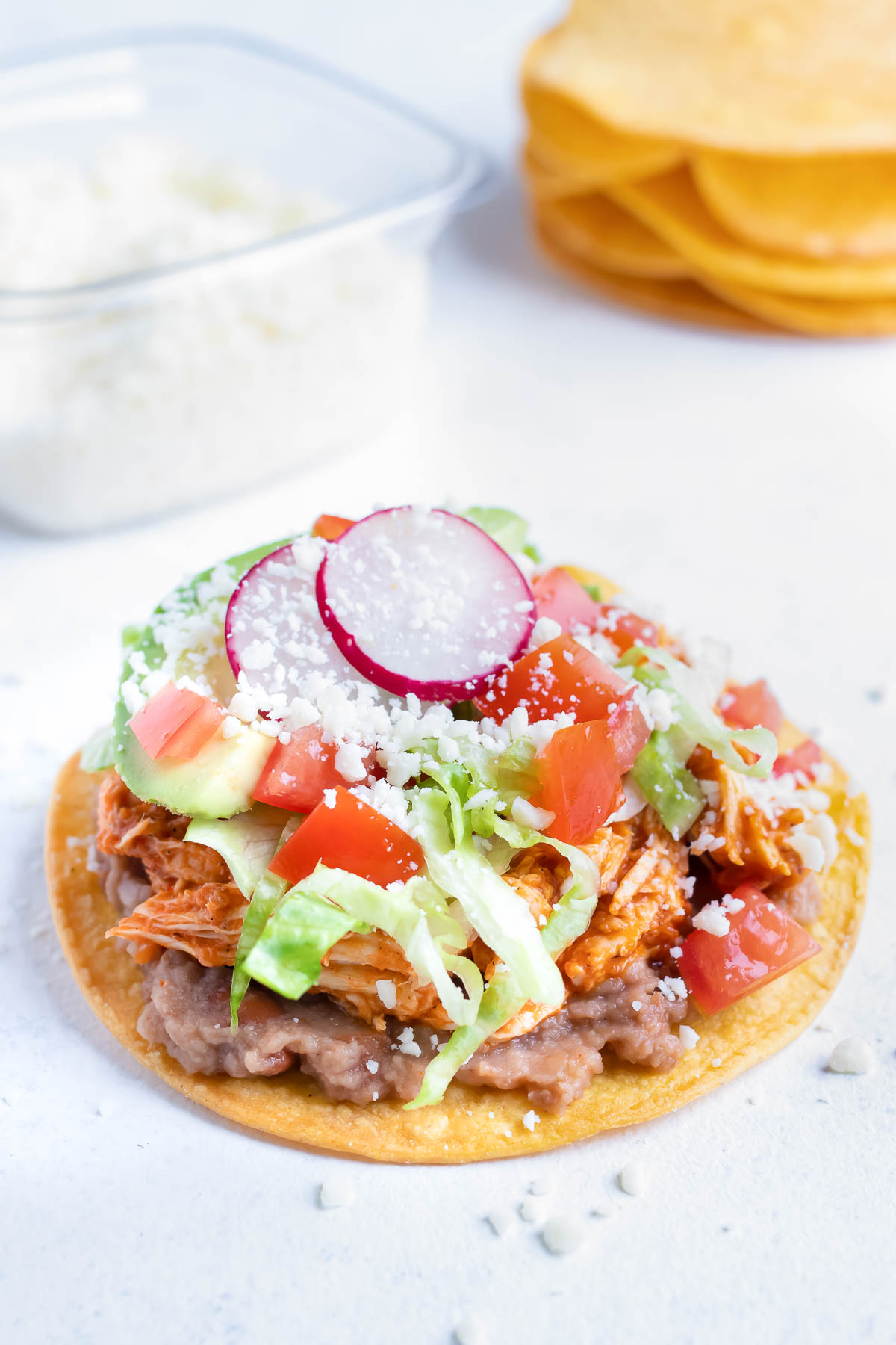 Sliced raddishes are added to the tostada.