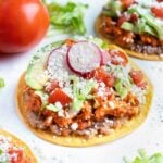 Easy chicken tinga tostadas are shown on the counter.