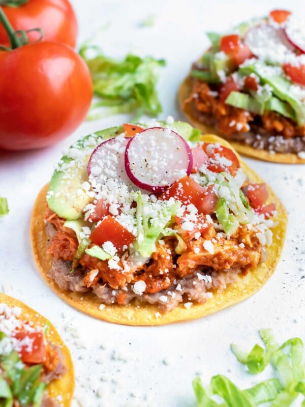 Easy chicken tinga tostadas are shown on the counter.