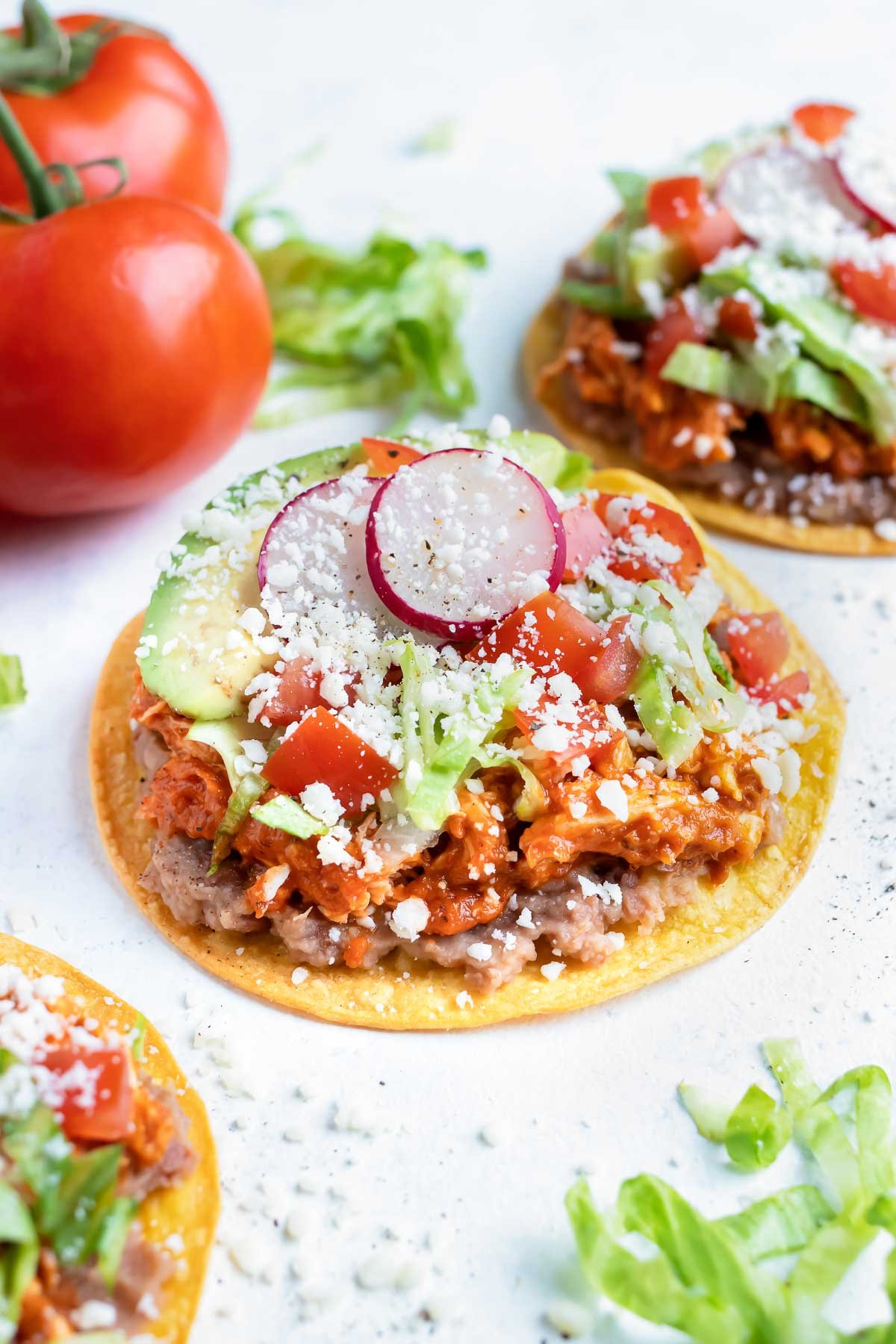 Easy chicken tinga tostadas are shown on the counter.
