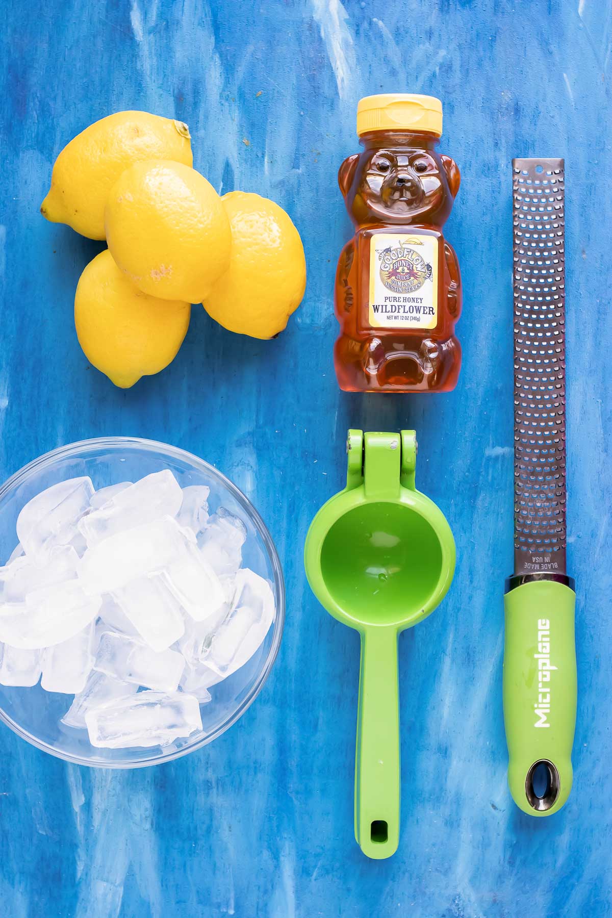 Lemons, honey, and ice as the ingredients for an easy frozen lemonade recipe.