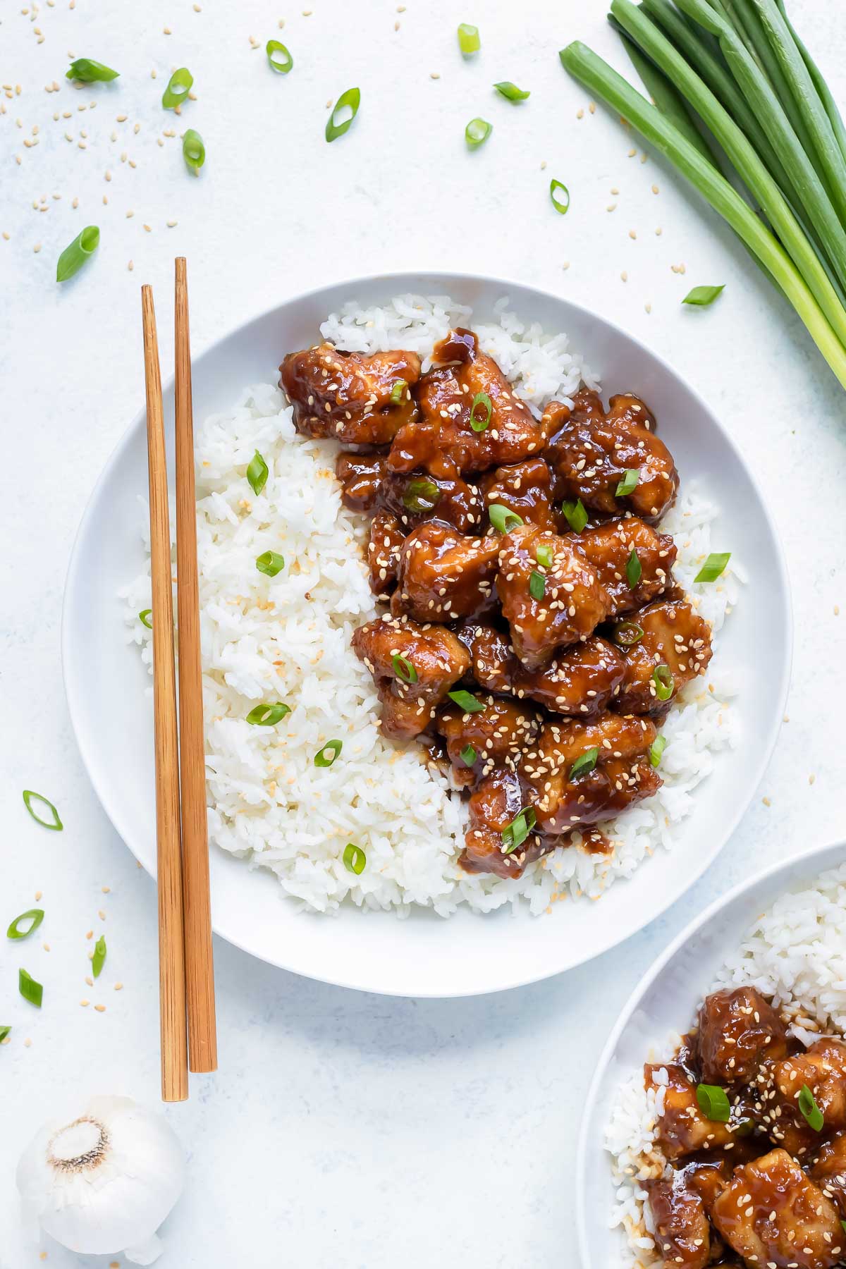 General Tso's Chicken is in a white bowl with cooked white rice.