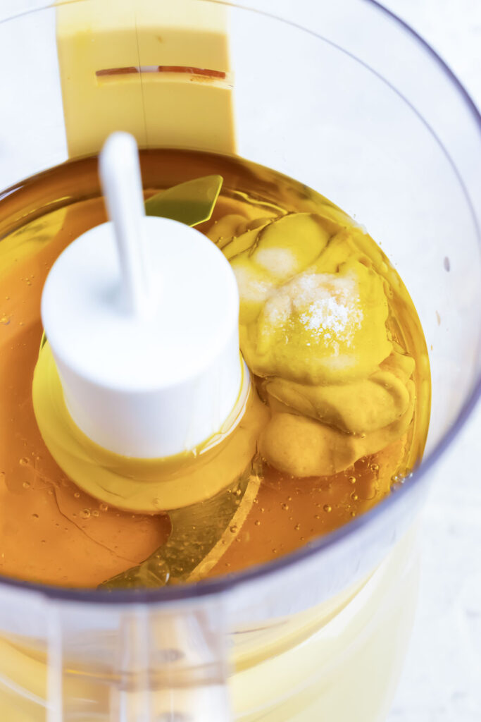 Ingredients for easy honey mustard dressing added to a food processor.