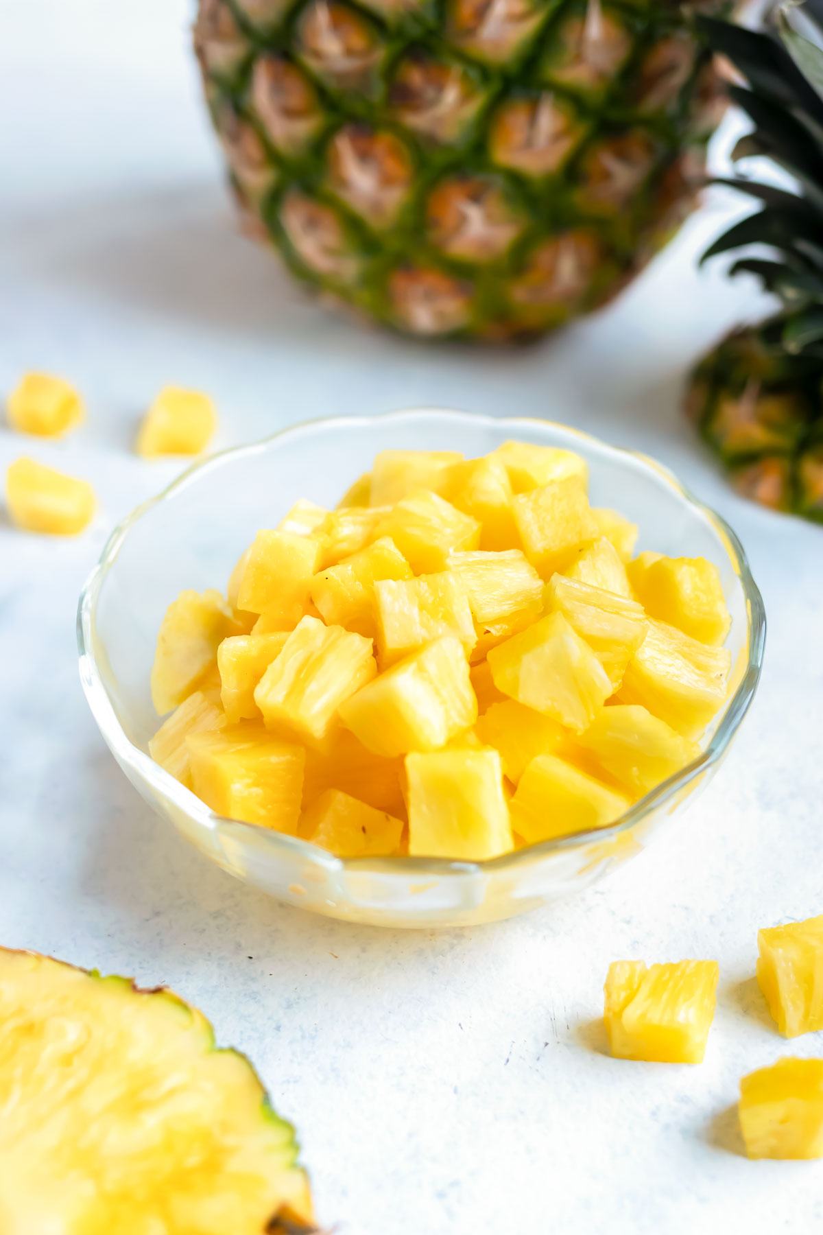A bowl of pineapple cubes is shown on the counter.