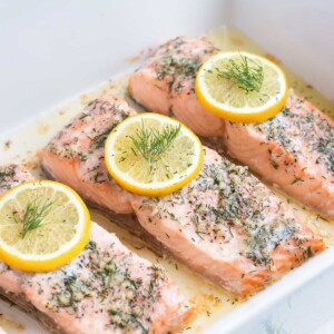 Lemon dill salmon is baked in the oven in a dish.