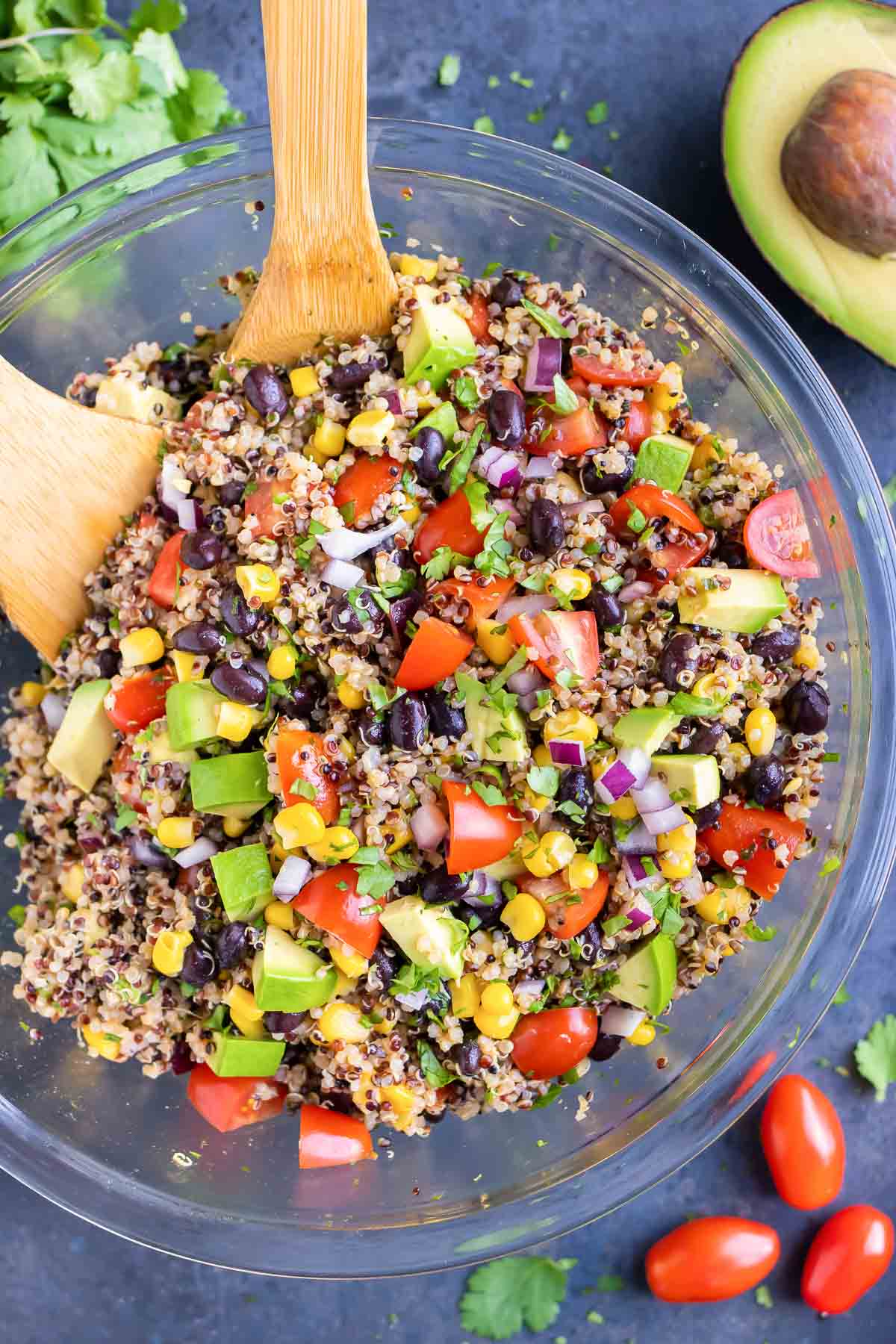 A Mexican Quinoa Salad with avocado in a clear glass bowl with a cilantro lime dressing.