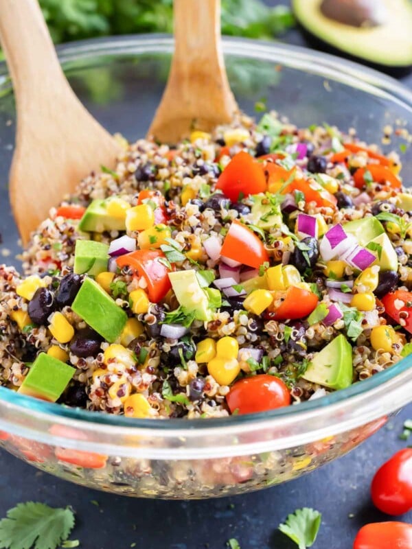 A Mexican Quinoa Salad with avocado in a clear glass bowl with a cilantro lime dressing.