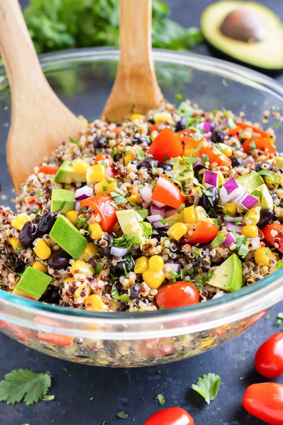 A Mexican Quinoa Salad with avocado in a clear glass bowl with a cilantro lime dressing.