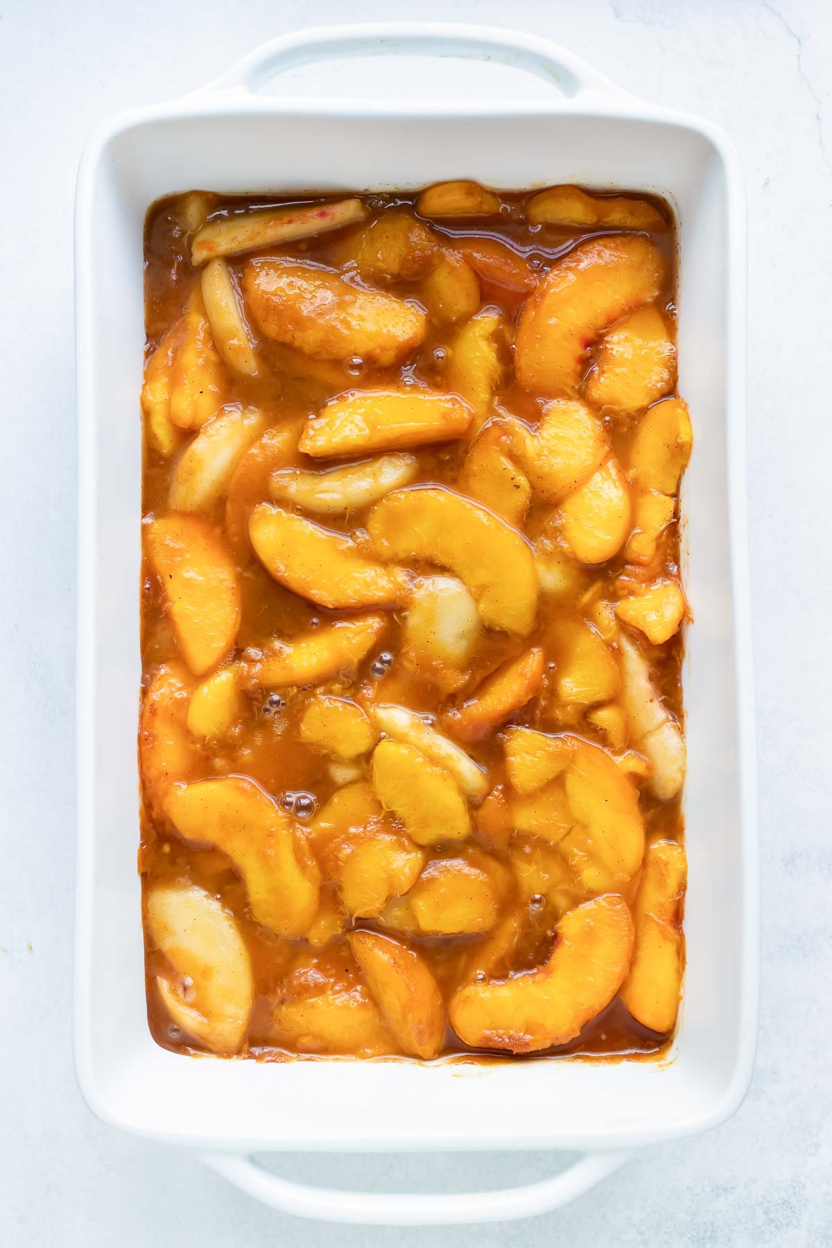 The peach filling is spread in the pan.