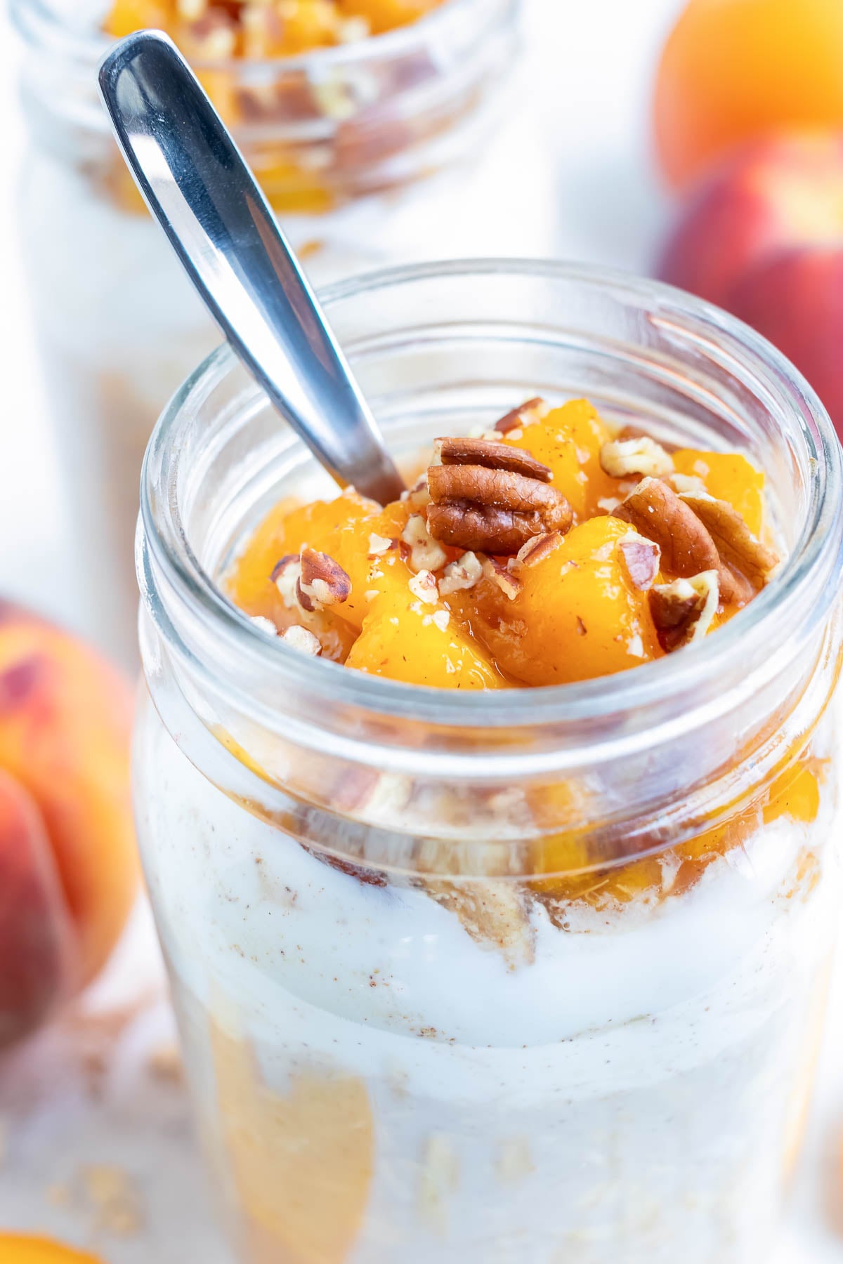 Peach oatmeal is made with yogurt, oats, and fresh peeled and sliced peaches and topped with toasted pecans for a delicious cobbler-like flavor.