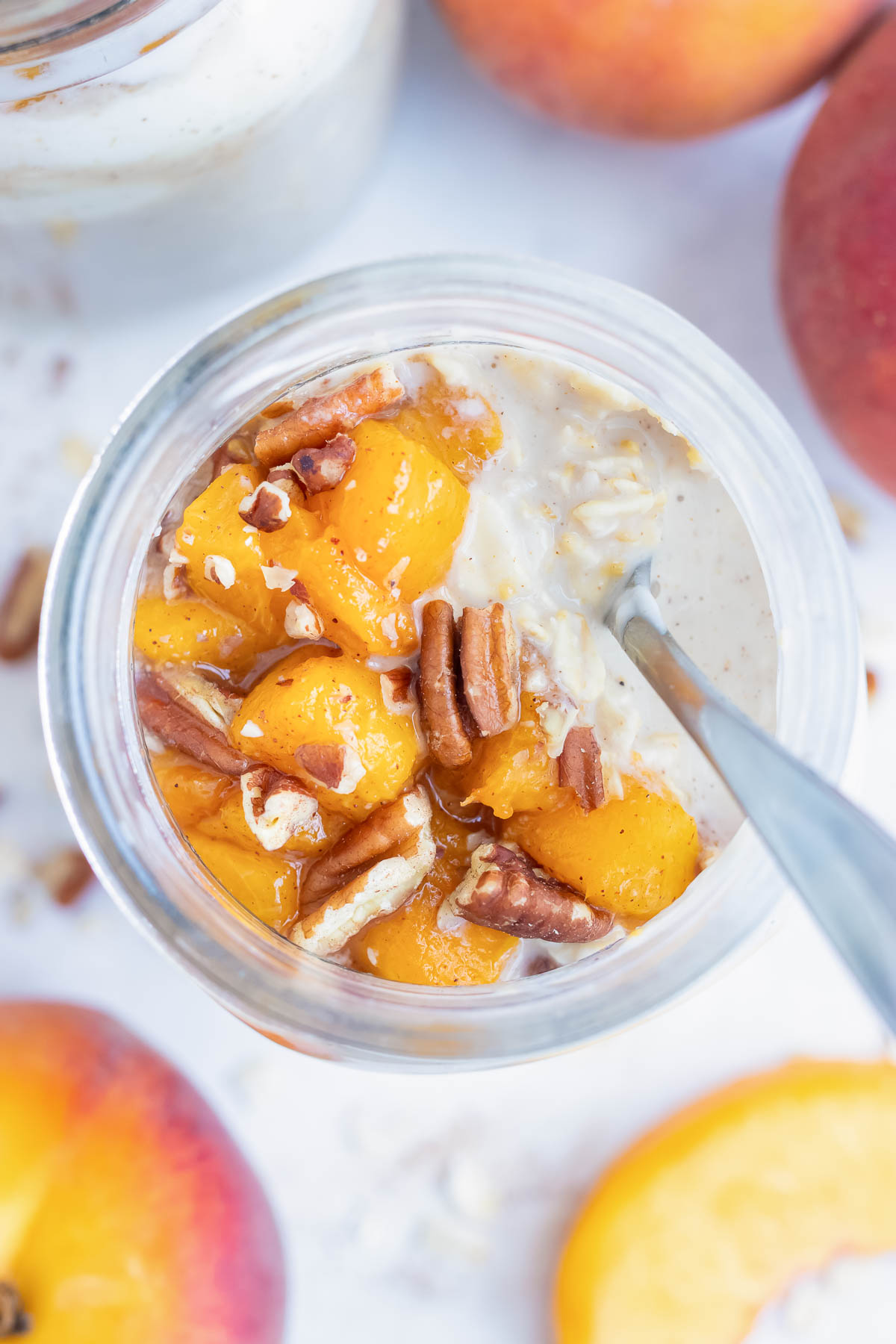 Mason jar meal prep oatmeal is made for an easy on-the-go breakfast, snack, or treat made with oats, fresh peaches, and toasted pecans.